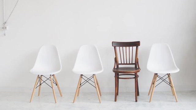 four chairs on a white background waiting for unemployed people for an interview.