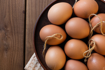  Eggs in a clay plate on a wooden table.