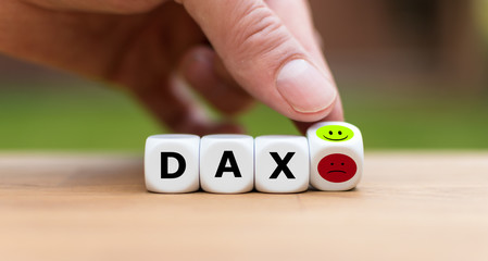 Better mood at the stock marked. Hand is turning a dice and changes a angry emoji to a happy emoji...