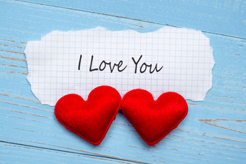 I LOVE YOU word on paper note with couple red heart shape decoration on blue wooden table background. Wedding, Romantic and Happy Valentine’ s day holiday concept