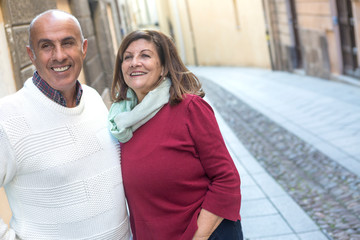 Coppia matura in vacanza passeggia felice per la città sfondo strada 