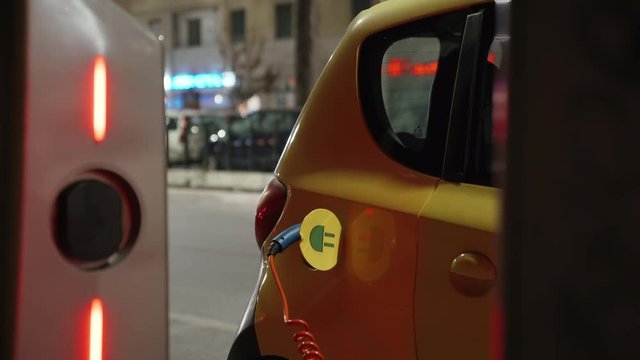 Eco energy, transport and power supply. Environmentally conscious transportation vehicle plugged in charger terminal. 4K.