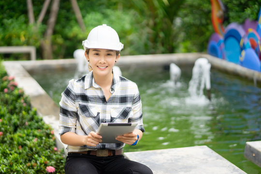 World Environment Day Concept ,Thai Asian Female Engineering Working With A Tablet Laptop At Sewage Treatment Plant, Engineer Controlling The Quality Of Water , Aerated Activated Sludge Tank