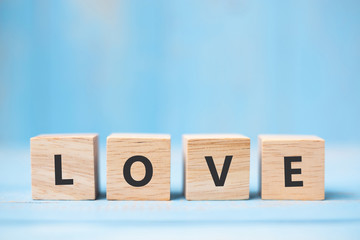 LOVE wooden cubes on blue table background with copy space for text. Wedding, Romantic and Happy Valentine’s day holiday concept