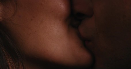 close up young caucasian couple kissing on rooftop at night enjoying romantic relationship embracing in peaceful urban evening watching beautiful city lights