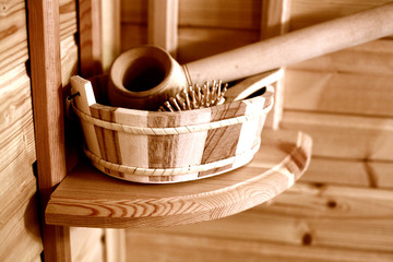 Fototapeta na wymiar Sauna set: wooden comb and bucket in a basket on the shelf. Side view.