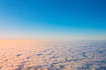 View on cloudy sky at sunrise from plane