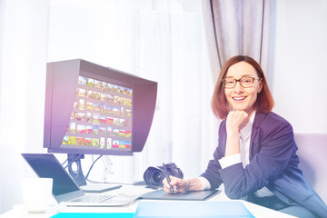 Happy woman working with graphic tablet in office