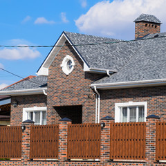 Asphalt shingle. Decorative bitumen shingles on the roof of a br