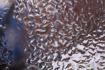 Water drops on glass window close up with blurred background. Drops in macro. Condensate on window closeup. Wet air.