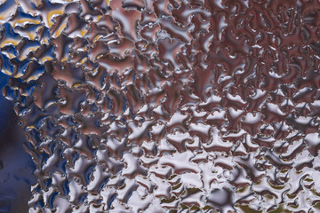 Water drops on glass window close up with blurred background. Drops in macro. Condensate on window closeup. Wet air.