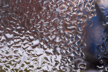 Water drops on glass window close up with blurred background. Drops in macro. Condensate on window closeup. Wet air.