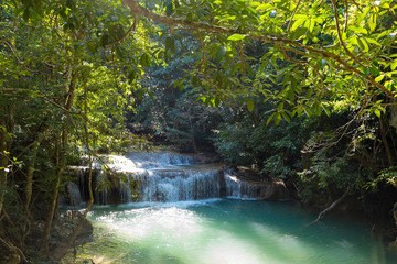 Fototapeta na wymiar Jangle landscape with flowing turquoise water of Erawan cascade waterfall