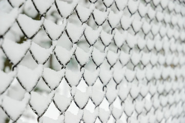 Snow-covered steel mesh fence