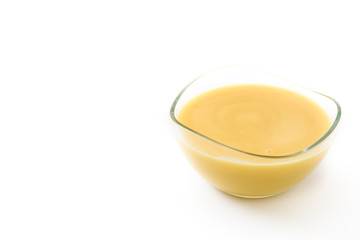Bowl of homemade vanilla custard isolated on white background. Copyspace