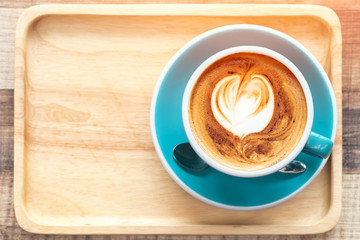 Late art coffee with heart shape on wood table background. Top view.