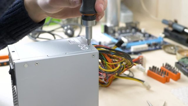 Repair power supply for computer. Repairman fixing components in computer unit