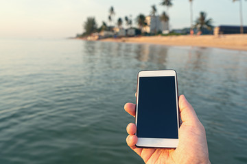 man using digital phone on the sea