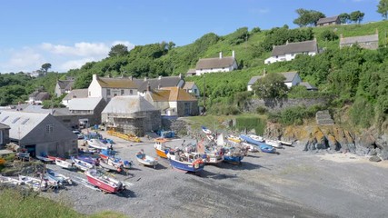 The beautiful tourist destination of Cadgwith, with fishing boats landed on the pebble beach.