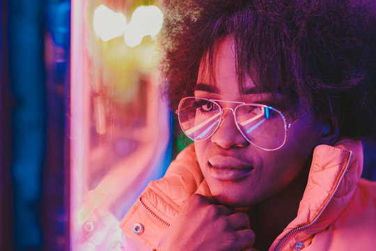 Black woman standing on night city street