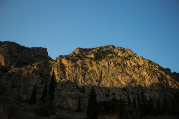 evening sunset contrast yellow bare mountain steep rock landscape foreshortening from below 