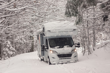 campervan caravan vehicle for van life holiday on camper van journey camping in mountains near the forest in the winter adventure season. snowing on the camper outdoor nomad lifestyle