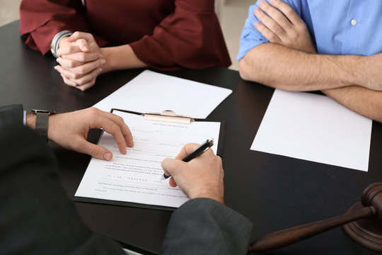 Unhappy young couple visiting divorce lawyer in office