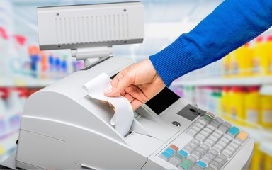 Cash register with LCD display and worker's hand holding receipt