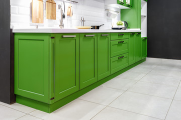 Classic kitchen interior with green trim. Kitchen acrylic countertop with built-in sink.