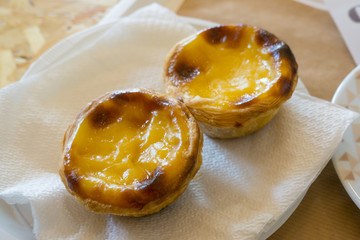 Delicious Pastel de Nata - traditional Portuguese custard tarts on a plate in a cafe in Algarve, Portugal