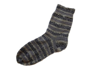 Hand knitted handmade black and brown color with striped pattern textured single isolated wool woolen warm sock on the white background