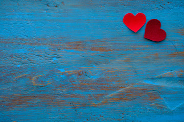 Two red hearts on a blue wooden board. Copy space
