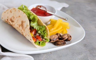 Tasty taco with french fries and sauce on plate