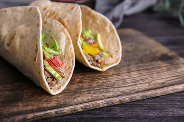 Tasty tacos on wooden board