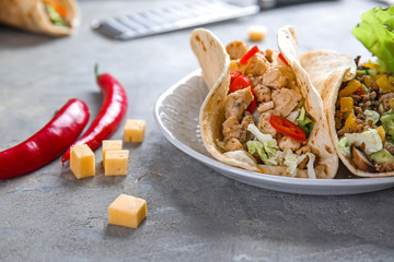 Plate with tasty tacos on grey table