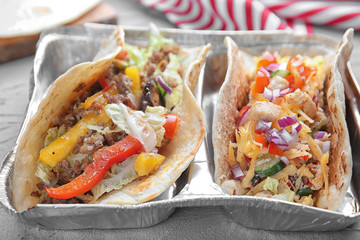 Tasty tacos on grey table