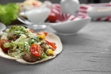 Tasty taco on grey table