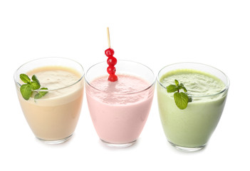 Glasses of tasty milkshakes on white background