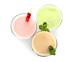 Glasses of tasty milkshakes on white background