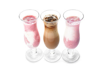 Glasses of tasty milkshakes on white background