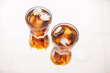 Glasses of tasty cold cola drink on light table