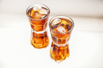 Glasses of tasty cold cola drink on light table