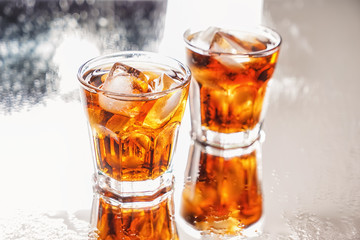 Glasses of tasty cold cola drink on light table