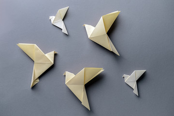 Origami birds on grey background