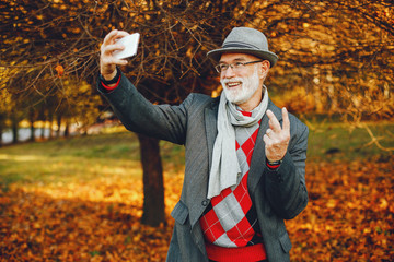 Elegant old man in a sunny autumn park 