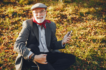 Elegant old man in a sunny autumn park 