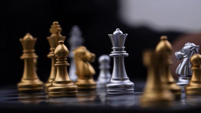 4K Close up shot hands of man playing golden and silver chess select focus shallow depth of field
