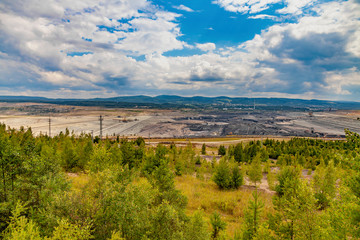 Fototapeta na wymiar Open coal mining pit with heavy machinery, Most, Czech Republic