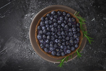 Blueberry vegan cheesecake. Dark photo on black background