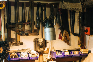 Workshop scene. Old tools hanging on wall in workshop. Vintage retro garage style. Old wrenches hanging wall in old garage.